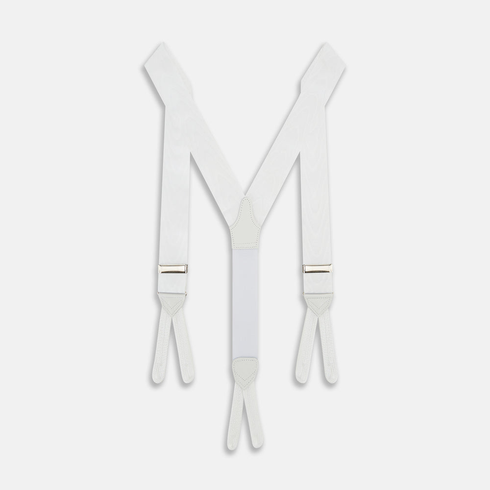 A pair of Casino Royale White Braces by Turnbull & Asser, as seen on James Bond, featuring elegant white moiré fabric with elastic suspender straps, metal adjusters, and leather ends—displayed on a plain white background.