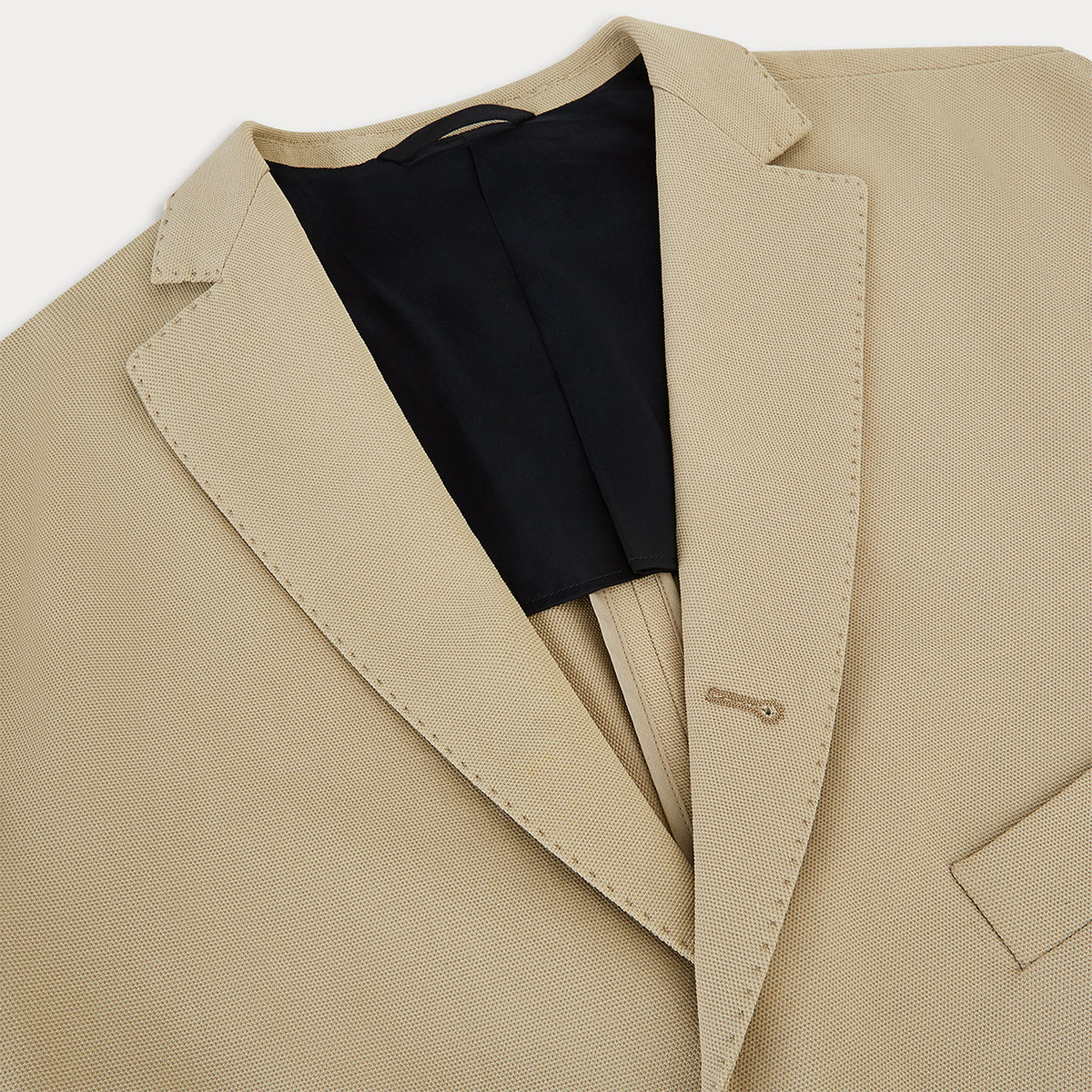 View 7 of product Riviera Sand Oversized Blazer in Cotton by Turnbull & Asser UK, featuring two spacious front pockets, a single chest pocket, and a classic notched lapel. Expertly tailored from premium cotton-nylon stretch fabric, this blazer is shown front-facing against a clean white background—an essential piece for achieving effortless sophistication.
