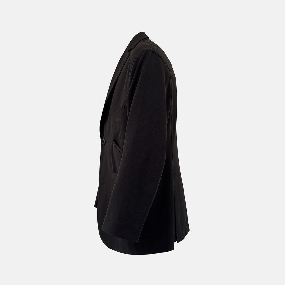 Introducing the Riviera Chocolate Oversized Blazer in Cotton by Turnbull & Asser UK—a dark brown blazer featuring two front buttons, three patch pockets, and notch lapels. Crafted from a cotton-nylon stretch fabric and showcased against a plain white background, this piece is a timeless addition to your autumn wardrobe.