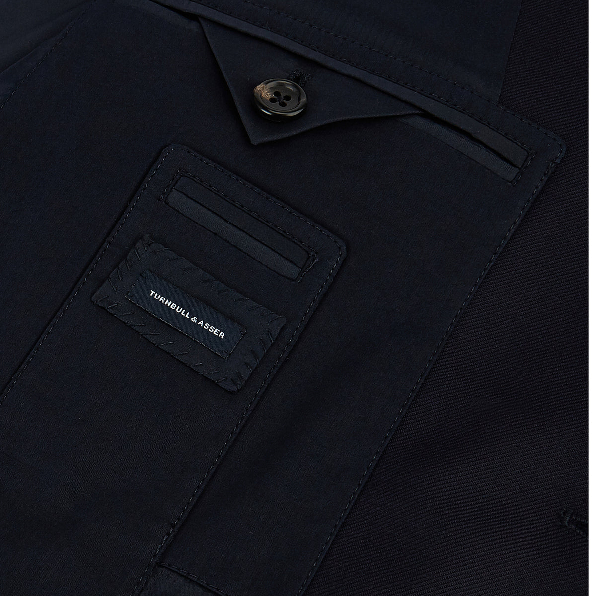 View 6 of product Turnbull & Asser UK Navy Single Breasted Classic Blazer in Wool Gabardine, a navy gabardine single-breasted blazer with two gold-tone buttons and a chest pocket, showcasing classic tailoring.