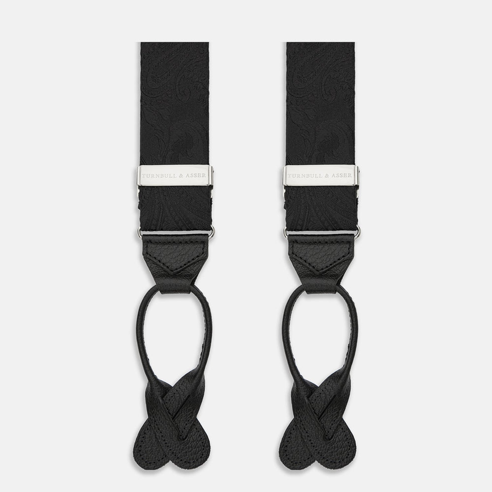 Turnbull & Asser's Black Paisley Adjustable Silk Braces feature silver-tone engraved clips and leather loop ends for button attachment, offering refined style. Shown against a white background.