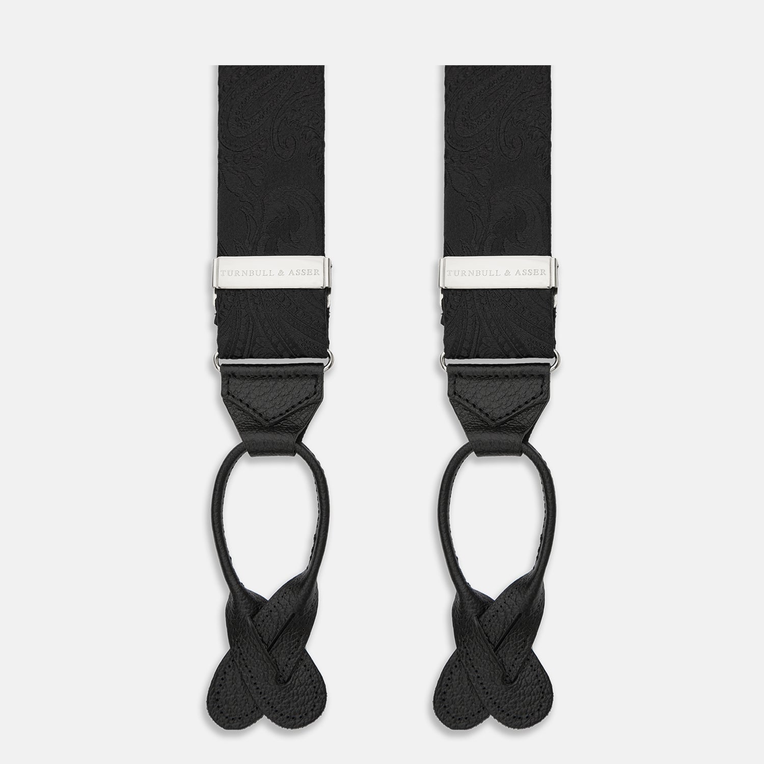 View 1 of product Turnbull & Asser's Black Paisley Adjustable Silk Braces feature silver-tone engraved clips and leather loop ends for button attachment, offering refined style. Shown against a white background.