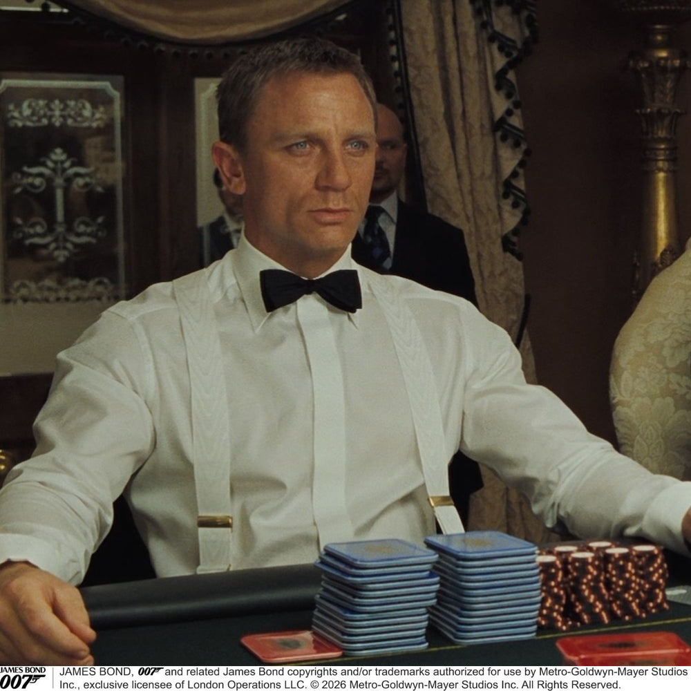 Two White Casino Royale Braces by Turnbull & Asser, as seen on James Bond, handmade in England with silver metal adjusters and leather detailing at the ends—displayed against a plain white background and offering the perfect finishing touch for a 007-inspired look.