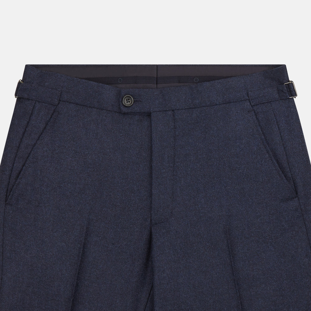 Turnbull & Asser’s Dark Blue Henry Trousers in a wool-cashmere blend feature a button closure, front pleats, and side pockets, shown laid flat on a white background.