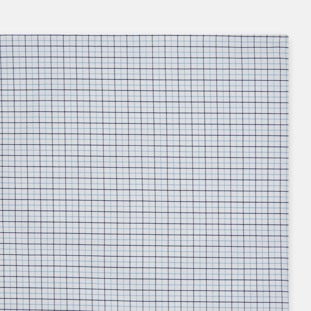 The Turnbull & Asser Hand Rolled Blue Double Graph Check Handkerchief features a cotton square with a blue and navy grid pattern, refined hand-rolled edges, and serves as an elegant gentleman's accessory.