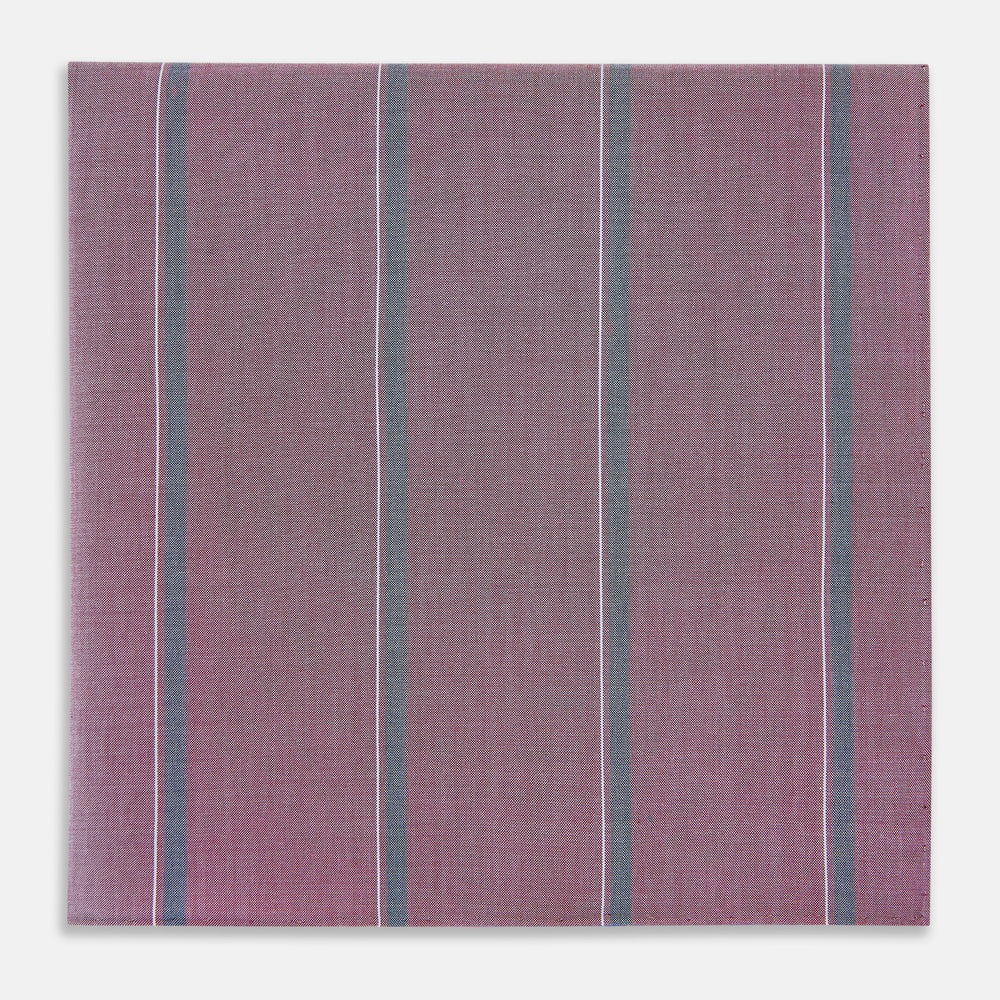 Crafted by Turnbull & Asser UK, the Cerise Red Track Stripe Hand-Rolled Handkerchief features a square design with a vibrant cerise red base accented by evenly spaced vertical blue and white stripes. Meticulously hand-rolled edges complete this elegant accessory, showcased against a plain light gray background.