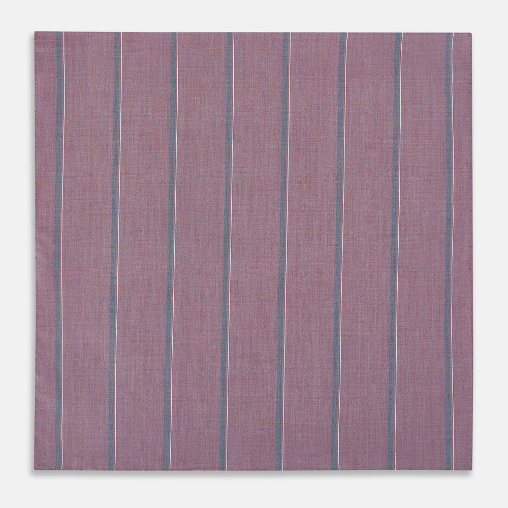 Crafted by Turnbull & Asser UK, the Cerise Red Track Stripe Hand-Rolled Handkerchief features a square design with a vibrant cerise red base accented by evenly spaced vertical blue and white stripes. Meticulously hand-rolled edges complete this elegant accessory, showcased against a plain light gray background.