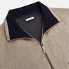 View 2 of product A Fairway Sand Golf Jacket in Linen by Turnbull & Asser UK, crafted from lightweight herringbone linen, features a front zipper, a chest zip pocket, two side zip pockets, and dark navy cuffs, collar lining, and waistband. Shown on a plain white background.