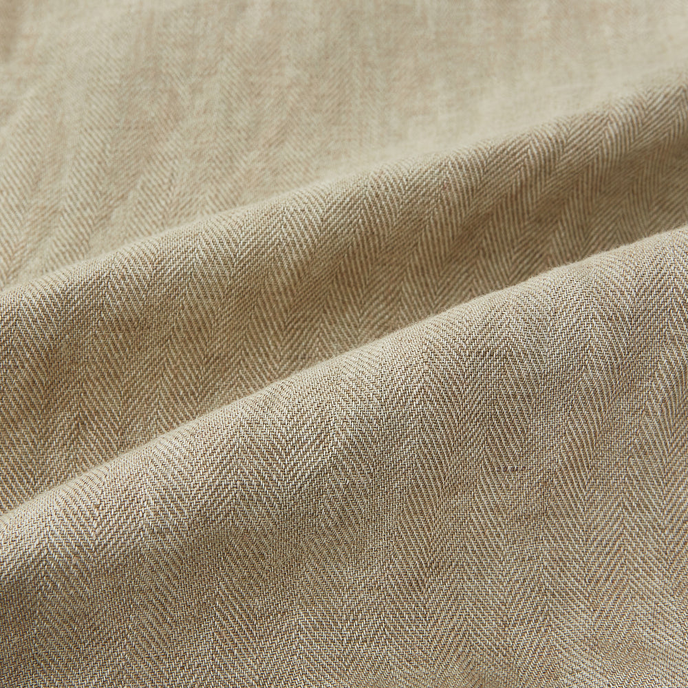 A Fairway Sand Golf Jacket in Linen by Turnbull & Asser UK, crafted from lightweight herringbone linen, features a front zipper, a chest zip pocket, two side zip pockets, and dark navy cuffs, collar lining, and waistband. Shown on a plain white background.