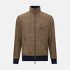 View 1 of product The Fairway Pinecone Golf Jacket in Linen by Turnbull & Asser UK is a brown zip-up jacket featuring a high collar, two side pockets, a zippered chest pocket, and dark cuffs and hem. Crafted from lightweight herringbone linen, it is displayed on a white background.