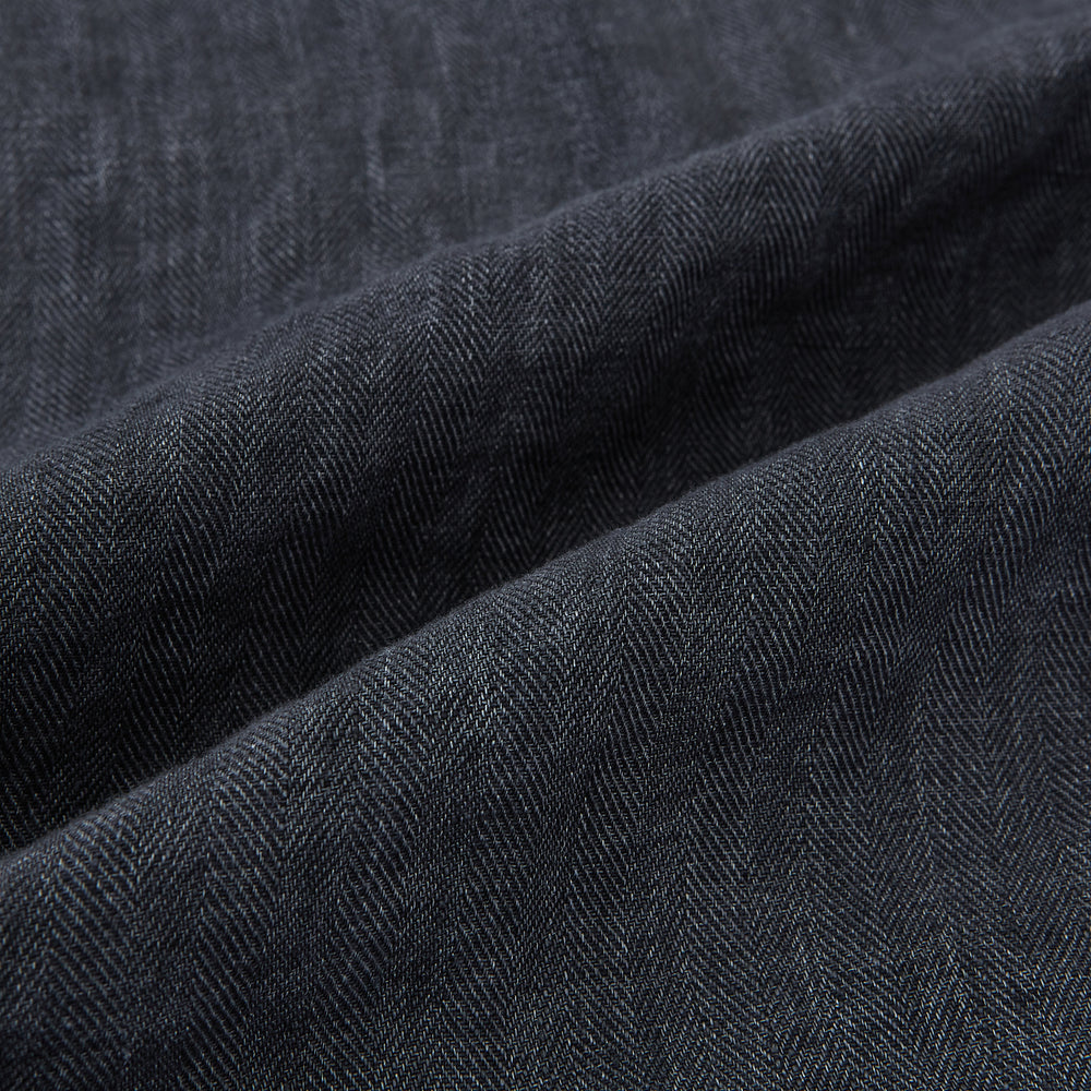 A front view of the Fairway Ash Golf Jacket in Linen by Turnbull & Asser UK is shown, featuring a high collar, two side zip pockets, a chest zip pocket, and black ribbed cuffs and hem. Crafted from lightweight gray herringbone linen for effortless warm-weather dressing, the jacket is displayed on a plain white background.