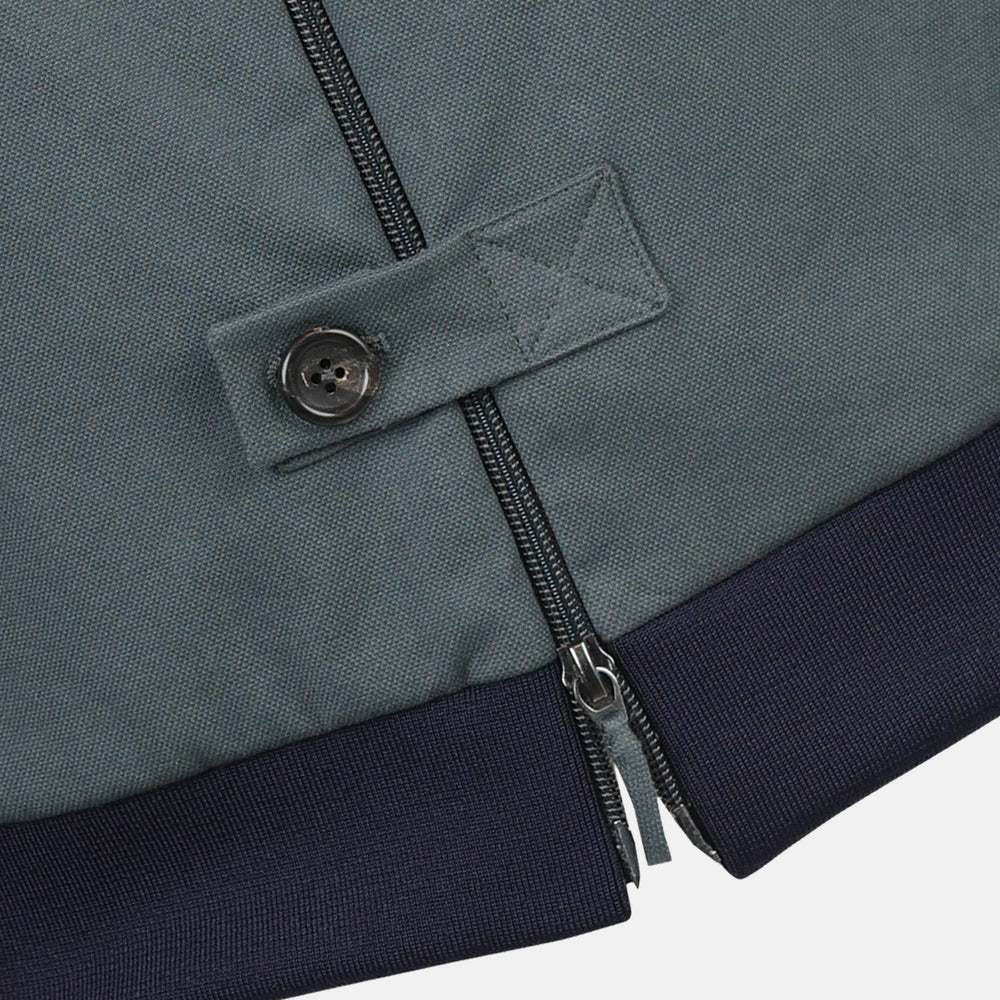 The Fairway Ash Grey Driving Jacket in Cotton by Turnbull & Asser UK features a zip-up design with a raised collar, black ribbed cuffs and hem, and multiple zippered pockets. Photographed on a plain white background, this essential piece from the Driver’s Capsule Collection is an iconic addition to any motoring wardrobe.
