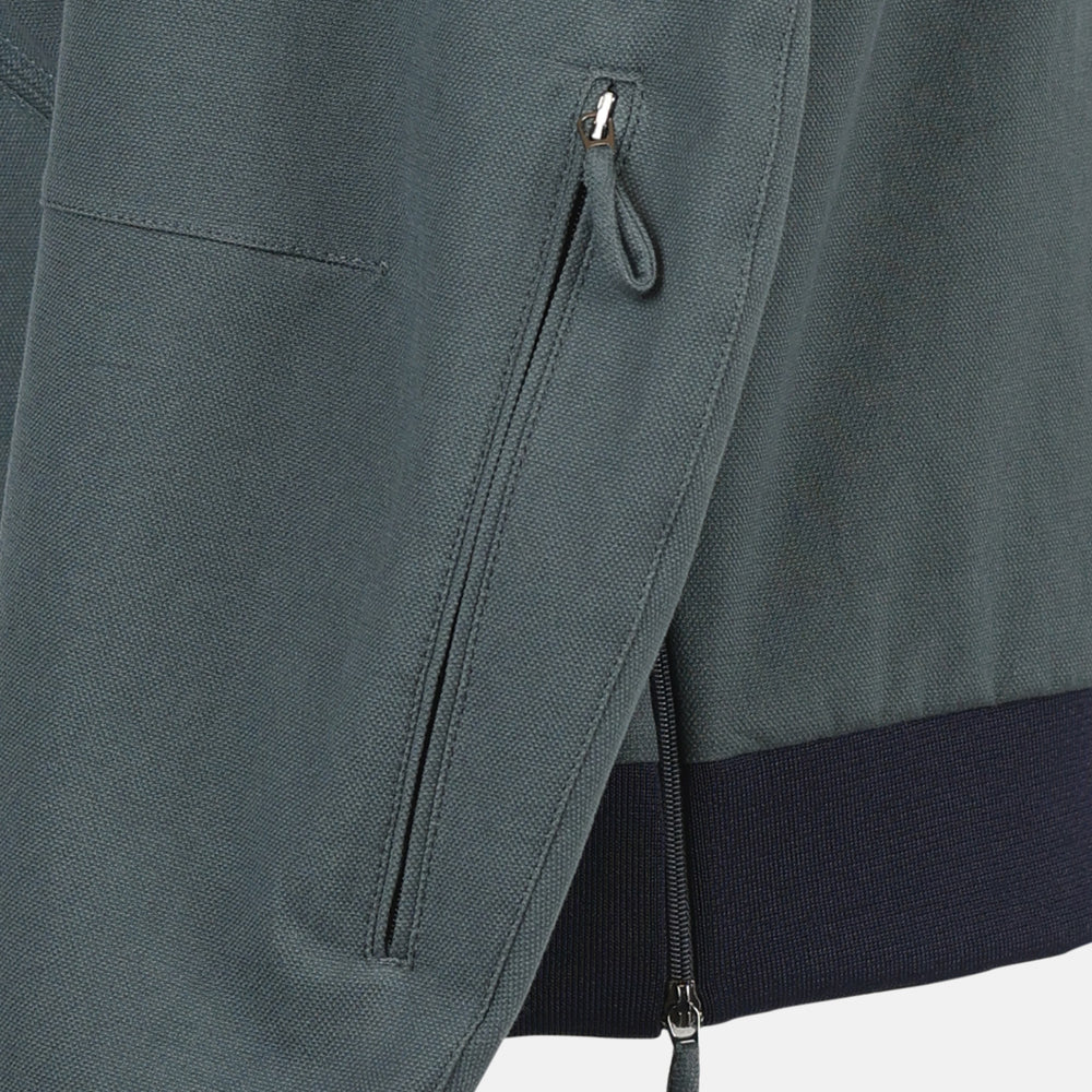 The Fairway Ash Grey Driving Jacket in Cotton by Turnbull & Asser UK features a zip-up design with a raised collar, black ribbed cuffs and hem, and multiple zippered pockets. Photographed on a plain white background, this essential piece from the Driver’s Capsule Collection is an iconic addition to any motoring wardrobe.