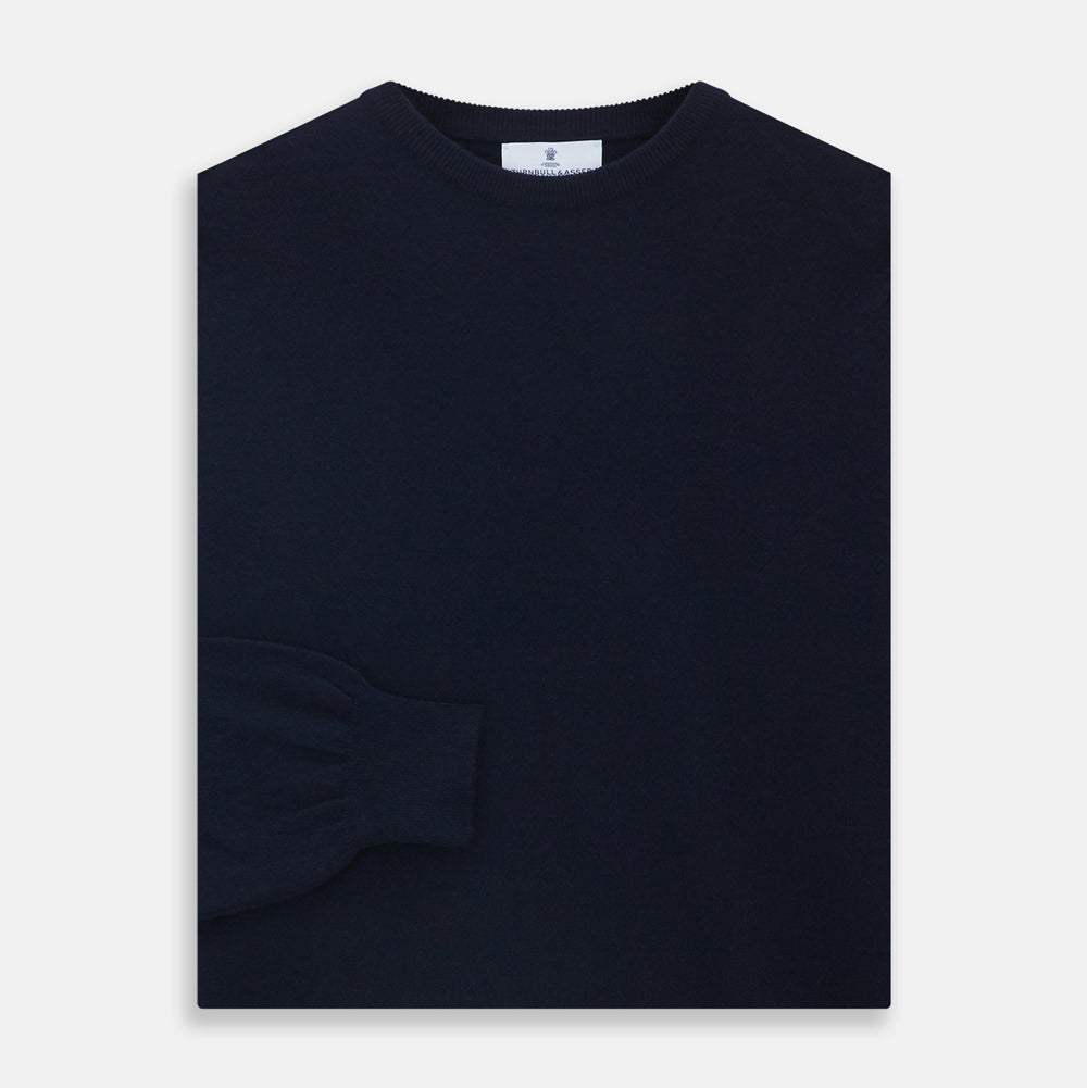 A luxurious navy crew neck cashmere jumper by Turnbull & Asser is laid flat on a white background, evoking timeless Scottish cashmere craftsmanship.