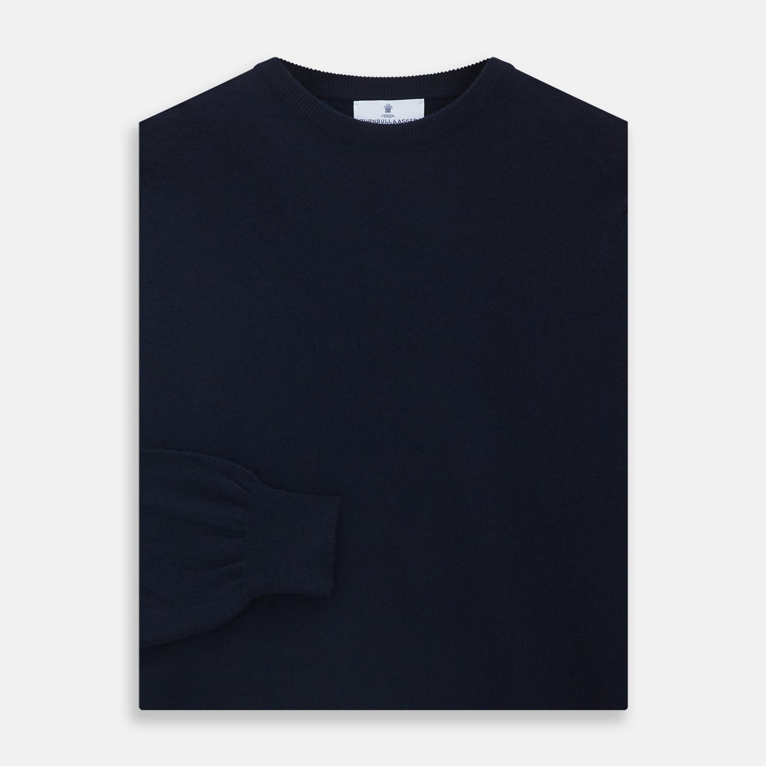 View 3 of product A luxurious navy crew neck cashmere jumper by Turnbull & Asser is laid flat on a white background, evoking timeless Scottish cashmere craftsmanship.