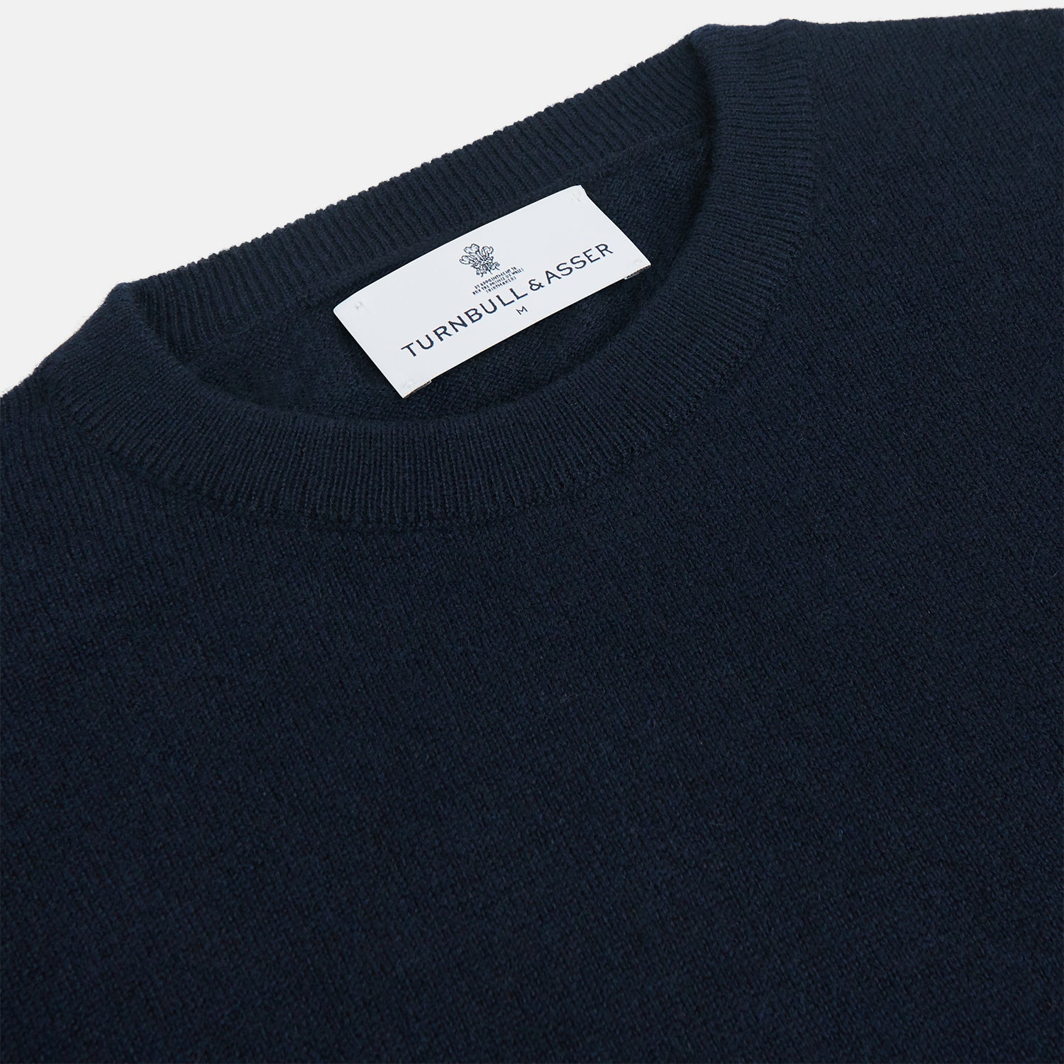 View 2 of product A luxurious navy crew neck cashmere jumper by Turnbull & Asser is laid flat on a white background, evoking timeless Scottish cashmere craftsmanship.