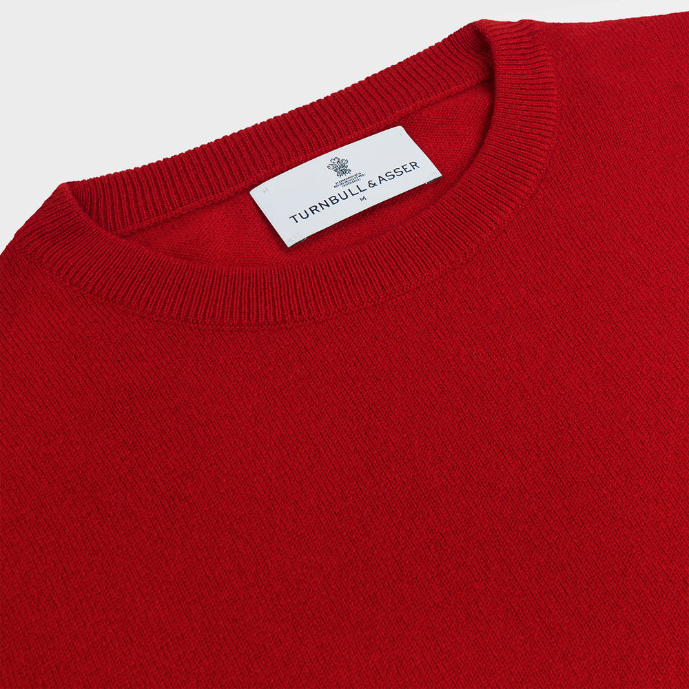 The Turnbull & Asser Deep Red Crew Neck Cashmere Jumper features long sleeves and a plain, solid hue—luxuriously soft and ideal for smart casual style. Displayed flat on a white background.