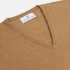 View 2 of product The Turnbull & Asser Natural V-Neck Cashmere Jumper, in camel, features long sleeves and ribbed cuffs, hem, and neckline. Crafted from Scottish cashmere, it’s laid flat on a white background for a refined smart casual look.