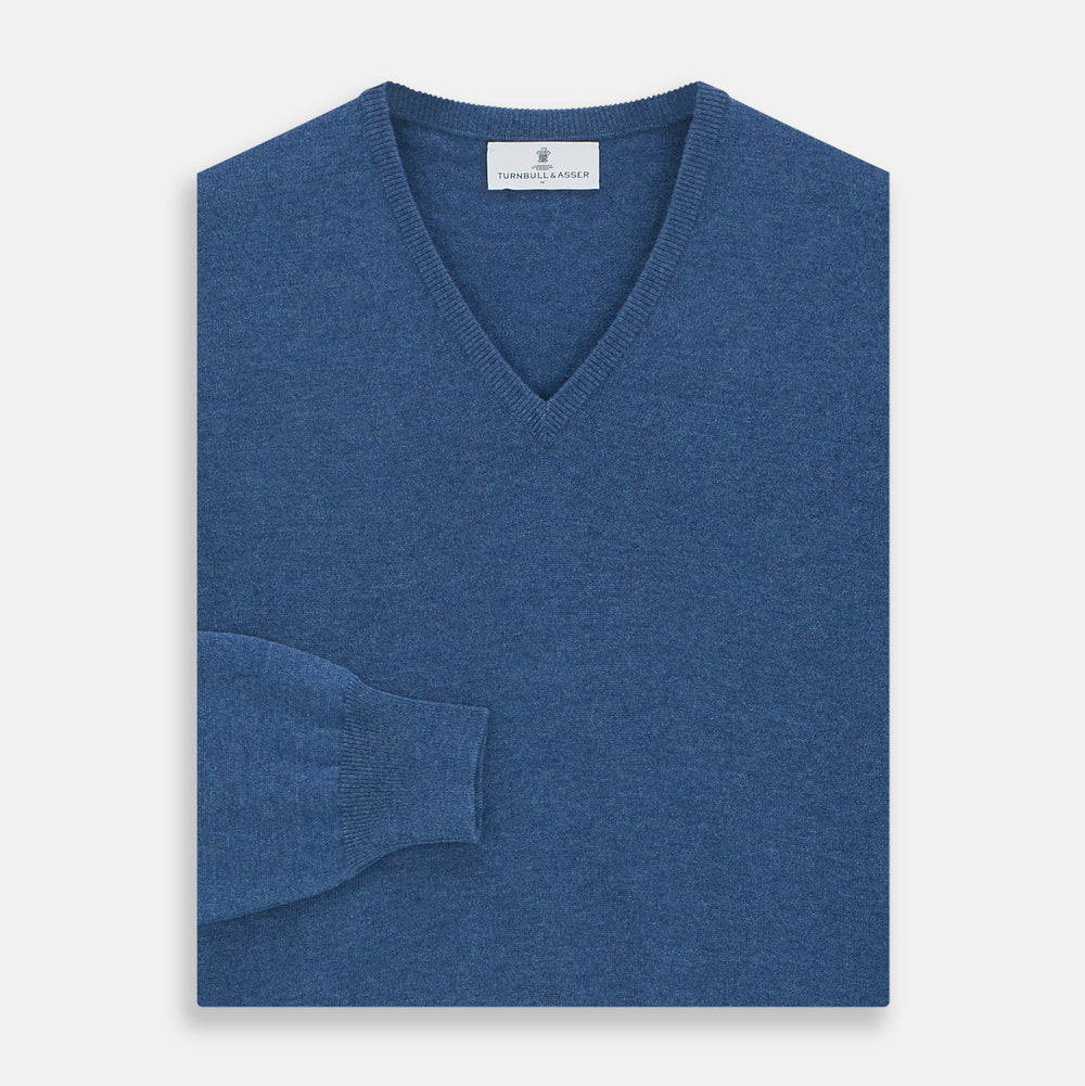 The Turnbull & Asser Blue V-Neck Cashmere Jumper, crafted from soft Scottish cashmere with ribbed cuffs, hem, and neckline, is shown laid flat on a white background for a refined smart-casual appeal.