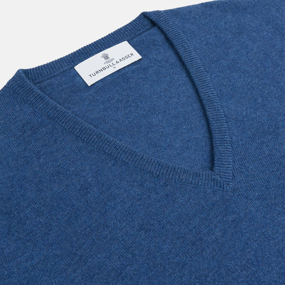 The Turnbull & Asser Blue V-Neck Cashmere Jumper, crafted from soft Scottish cashmere with ribbed cuffs, hem, and neckline, is shown laid flat on a white background for a refined smart-casual appeal.