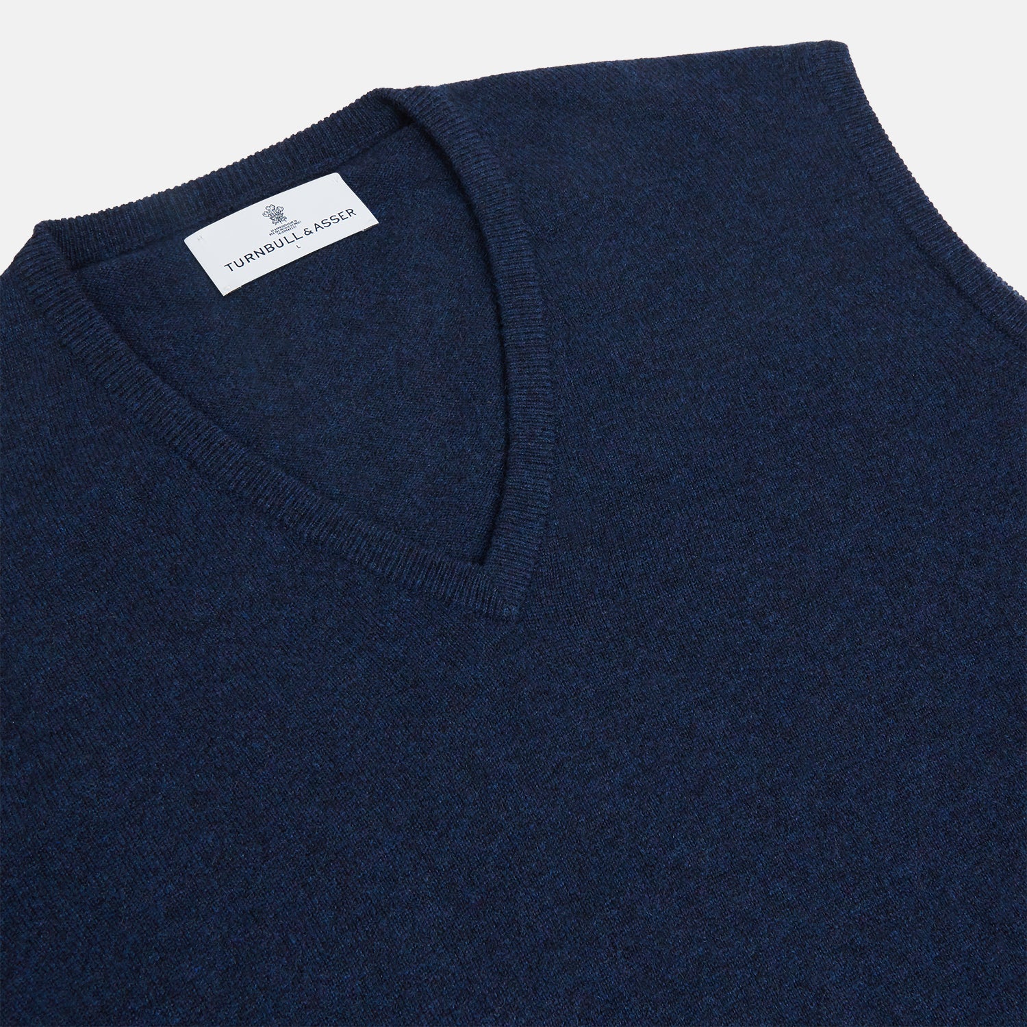 View 2 of product A neatly folded Turnbull & Asser Navy V-Neck Cashmere Slipover is displayed on a plain white background, its inner neckline label visible.