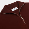 View 2 of product The Turnbull & Asser Port Cashmere Half-Zip Jumper is a dark maroon, long-sleeve style with a high collar, silver half-zip, and ribbed cuffs and hem, shown laid flat on a white background—ideal for layering.