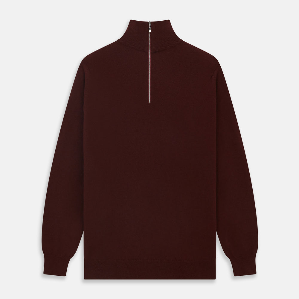 The Turnbull & Asser Port Cashmere Half-Zip Jumper is a dark maroon, long-sleeve style with a high collar, silver half-zip, and ribbed cuffs and hem, shown laid flat on a white background—ideal for layering.
