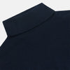 View 2 of product The Turnbull & Asser Navy Cashmere Roll Neck Jumper, with ribbed cuffs and hem, is a timeless autumn essential. Shown laid flat on a white background, this plain long-sleeved sweater offers classic style and comfort.