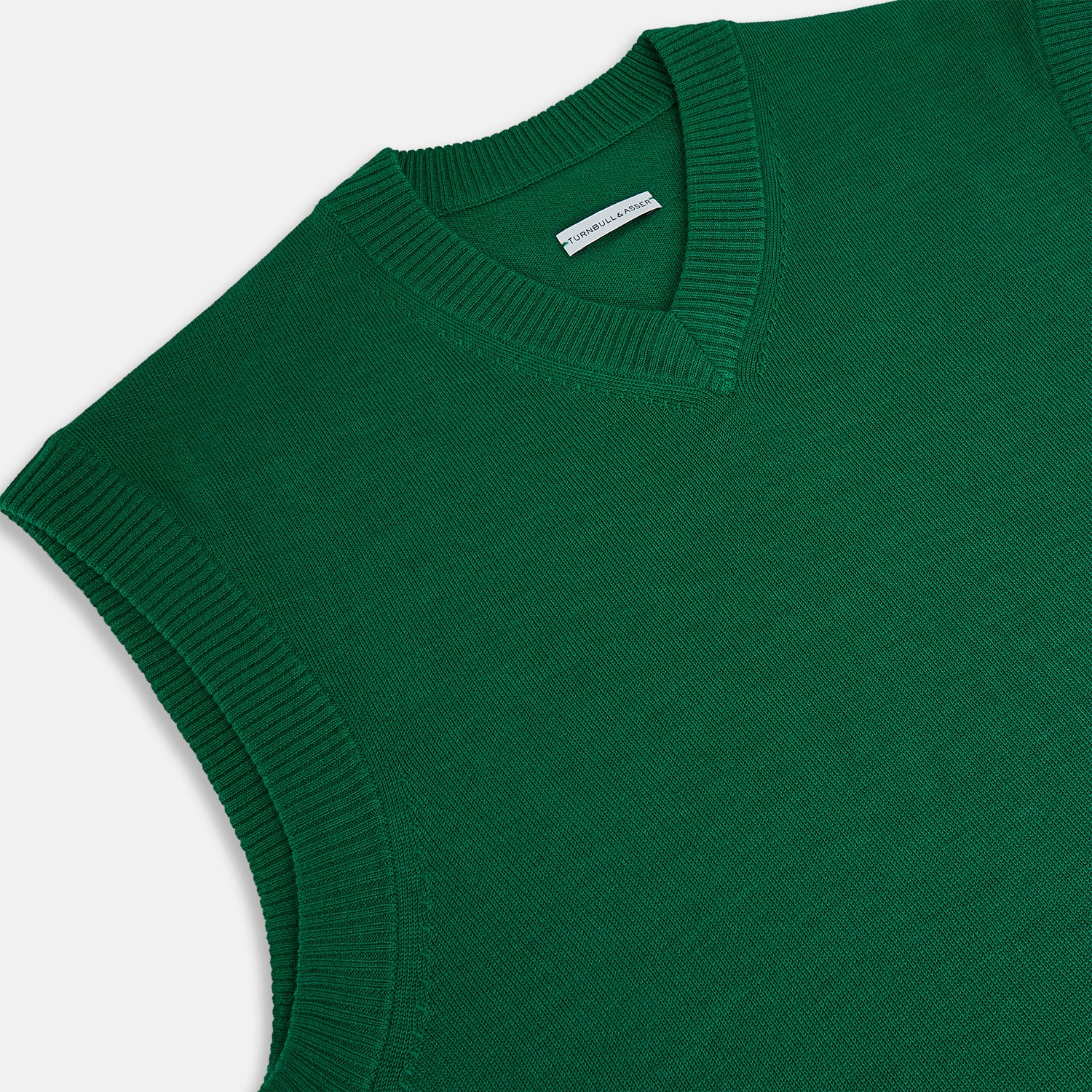 View 2 of product The Turnbull & Asser Hunter Green Fine Merino V-Neck Vest features a sleeveless design with ribbed edges, making it a stylish sweater vest for any gentleman. Shown against a plain white background.