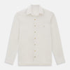 View 1 of product The Turnbull & Asser White Pique Shirt is a long-sleeve, white button-up with a chest pocket and beige buttons, laid flat on a white background, featuring an elevated silhouette inspired by elegant polos.