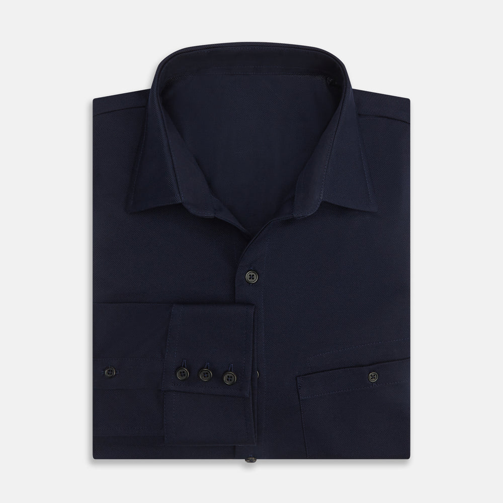 The Turnbull & Asser Navy Pique Shirt is a long-sleeved, dark navy button-up with a left chest pocket, classic collar, and buttoned cuffs, shown laid flat on a white background.