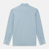 View 3 of product The Turnbull & Asser Pale Blue Pique Shirt is a long-sleeve button-up with an open collar, single chest pocket, and beige buttons, shown against a white background.