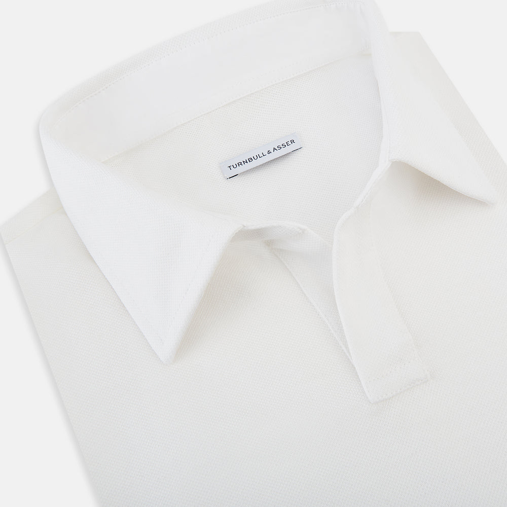A Cream Rugby Polo Shirt in Cotton by Turnbull & Asser UK, featuring long sleeves, a collar, and a partial button placket, is displayed on a white background.
