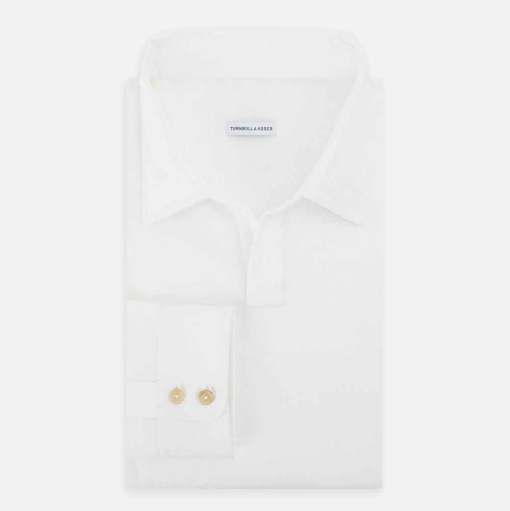 A Cream Rugby Polo Shirt in Cotton by Turnbull & Asser UK, featuring long sleeves, a collar, and a partial button placket, is displayed on a white background.