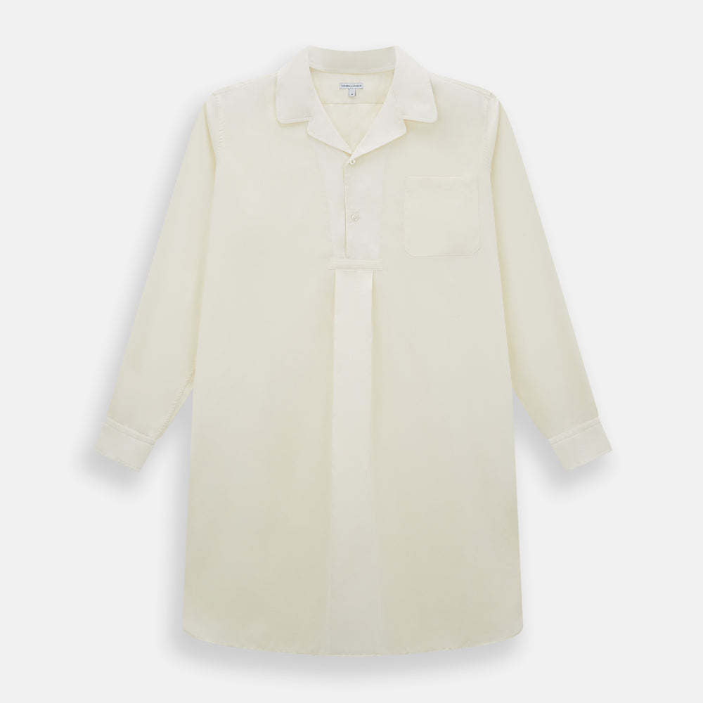 The Cream Nightshirt by Turnbull & Asser is a long-sleeved, cream-colored shirt dress with a collar, partial button front, chest pocket, and relaxed fit—ideal as comfortable sleepwear—shown on a plain white background.