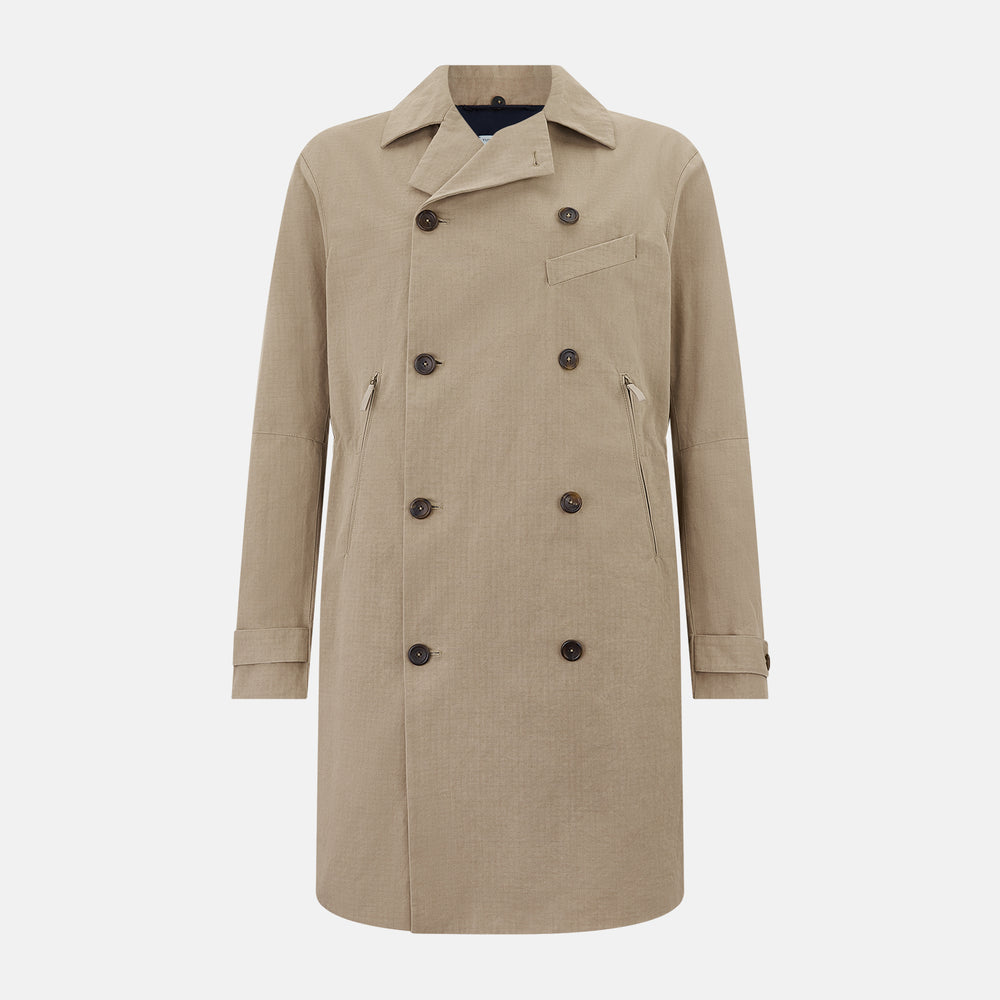The Sand Long Albert Trench Coat by Turnbull & Asser UK features a double-breasted design, dark buttons, notched collar, and two slanted front pockets, offering timeless British style. Shown against a plain white background.