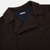 View 2 of product The Turnbull & Asser UK Dark Chocolate Short Albert Trench Coat features a double-breasted style, black buttons, notched collar, chest pocket, two side zip pockets, and adjustable cuff straps—shown on a plain white background.