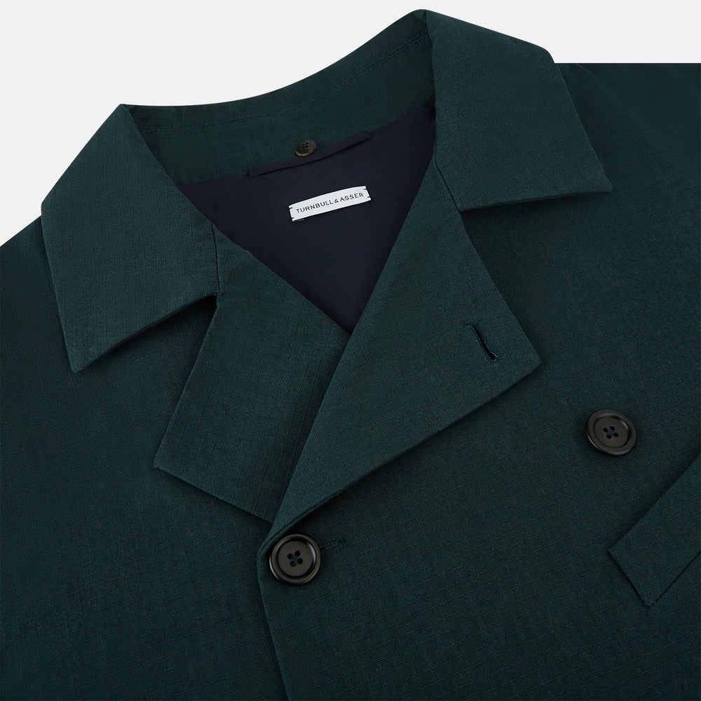 Turnbull & Asser UK's Forest Green Short Albert Trench Coat features a double-breasted design, black buttons, front chest pocket, two zippered side pockets, and strapped cuffs, shown against a plain white background.