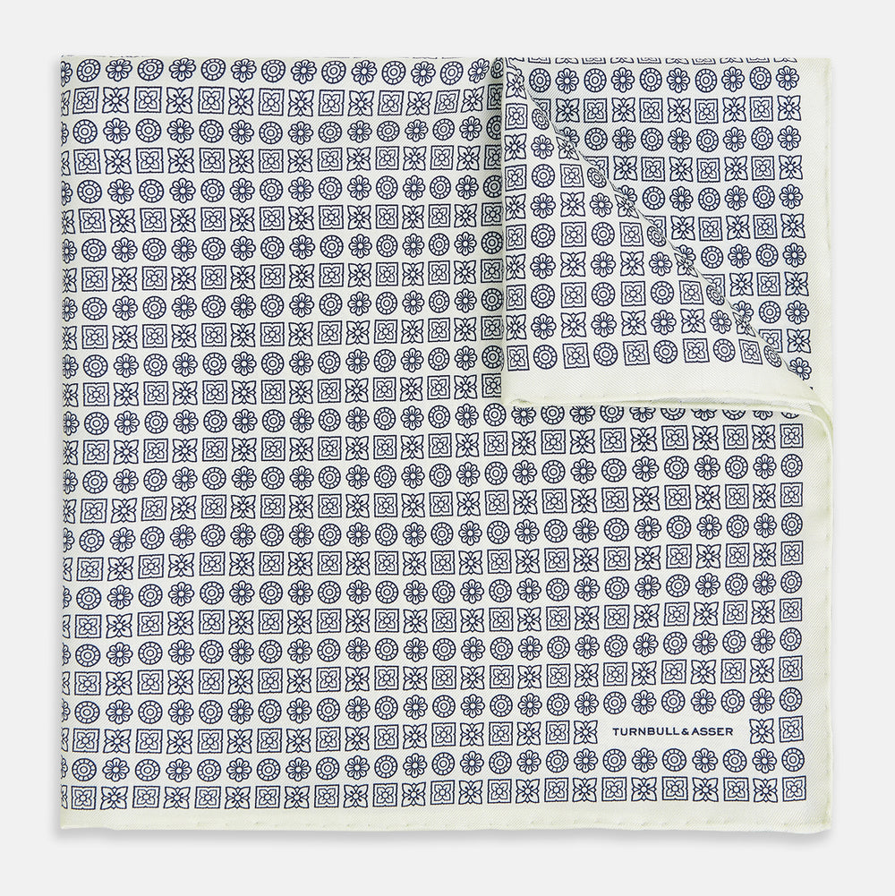 A white silk pocket square from Turnbull & Asser UK, featuring a floral pattern and discreetly finished with the brand’s logo in one corner, this Floral White Pocket Square is neatly folded to showcase both its design and craftsmanship.