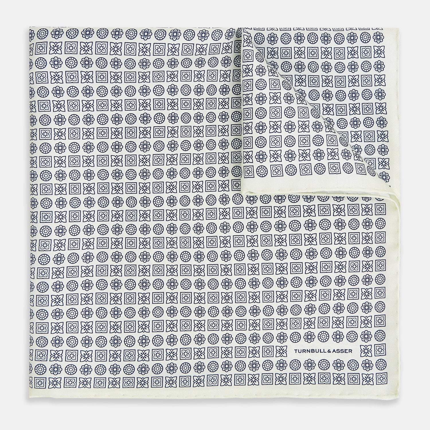 View 1 of product A white silk pocket square from Turnbull & Asser UK, featuring a floral pattern and discreetly finished with the brand’s logo in one corner, this Floral White Pocket Square is neatly folded to showcase both its design and craftsmanship.