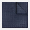 View 1 of product A Floral Navy Pocket Square in Silk by Turnbull & Asser UK, featuring a repeating geometric pattern with the brand’s name printed in white in the corner—perfect for adding a touch of sophistication to formal tailoring. The top right edge is folded over to reveal the reverse side.