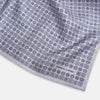 View 2 of product A lilac silk pocket square featuring a repeating geometric rosette pattern. One corner is folded over to show the reverse side, and "Turnbull & Asser UK" is printed in the bottom right corner.