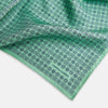View 2 of product Floral Green Pocket Square in Silk by Turnbull & Asser UK, showcasing navy-blue floral geometric motifs on a bright green background. One corner is neatly folded to display both sides of the silk fabric, with "Turnbull & Asser UK" printed in the lower right corner.