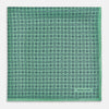 View 3 of product Floral Green Pocket Square in Silk by Turnbull & Asser UK, showcasing navy-blue floral geometric motifs on a bright green background. One corner is neatly folded to display both sides of the silk fabric, with "Turnbull & Asser UK" printed in the lower right corner.
