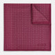 A folded Floral Burgundy Pocket Square in Silk by Turnbull & Asser UK, adorned with pink floral geometric motifs and featuring the Turnbull & Asser logo in the bottom right corner.