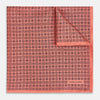 View 1 of product The Floral Orange Pocket Square in Silk by Turnbull & Asser UK features a coral and navy geometric floral pattern with orange accents, neatly folded at the corner. The brand name, Turnbull & Asser UK, is printed in white near the edge.