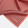 View 2 of product The Floral Orange Pocket Square in Silk by Turnbull & Asser UK features a coral and navy geometric floral pattern with orange accents, neatly folded at the corner. The brand name, Turnbull & Asser UK, is printed in white near the edge.