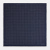 View 4 of product Checked Navy On White Pocket Square in Silk by Turnbull & Asser UK, featuring a navy blue geometric pattern with a white dotted grid and a solid border. The pocket square is shown with one corner folded over to display the “TURNBULL & ASSER” label in white text.