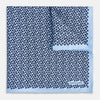 View 1 of product A light blue double-sided pocket square made of silk, featuring a dense pattern of small, dark blue floral motifs. One corner is folded over to reveal the Turnbull & Asser UK brand name printed in blue.