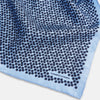 View 2 of product A light blue double-sided pocket square made of silk, featuring a dense pattern of small, dark blue floral motifs. One corner is folded over to reveal the Turnbull & Asser UK brand name printed in blue.
